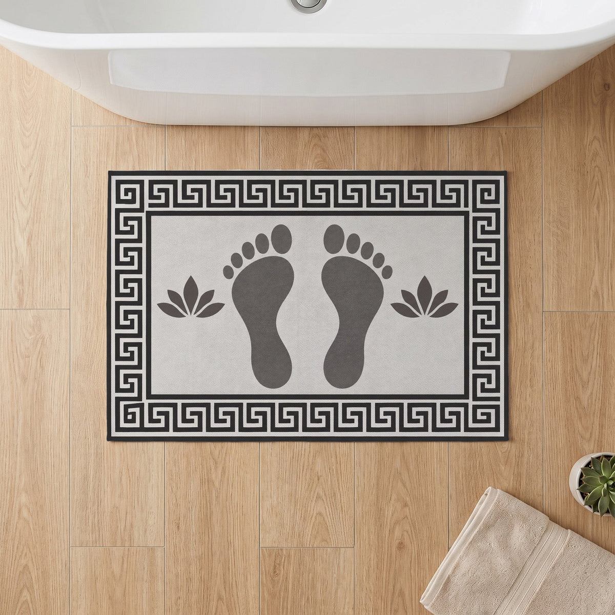 Kartela Footprints washable footprint bath mat in Charcoal, on a wooden floor in front of a bathtub