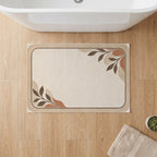 Kartela Diatomite washable stone-look bath mat in Beige, on a wooden floor in front of a bathtub