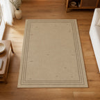 Kartela Weathered Line washable distressed bordered area rug in Beige, on a wooden floor in a bright living room