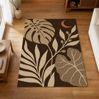 Kartela Night Garden washable tropical leaf area rug in Beige, on a wooden floor in a bright living room