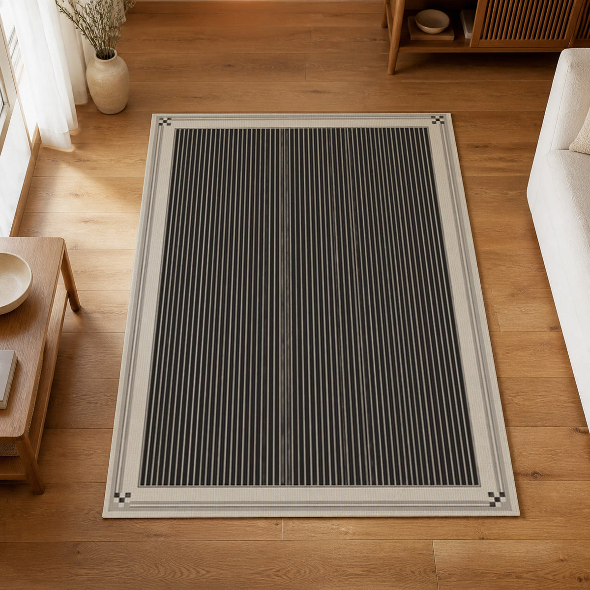 Kartela Fine Stripe washable striped bordered area rug in Charcoal, on a wooden floor in a bright living room
