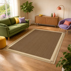 Kartela Fine Stripe washable striped bordered area rug in Beige, in a sunny living room with a green sofa