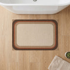 Kartela Jute Frame washable jute-look bath mat in Beige, on a wooden floor in front of a bathtub