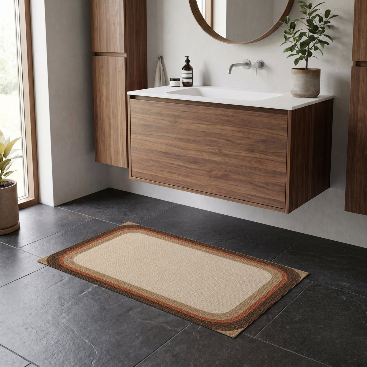 Kartela Jute Frame washable jute-look bath mat in Beige, on a dark tile floor in front of a wooden vanity
