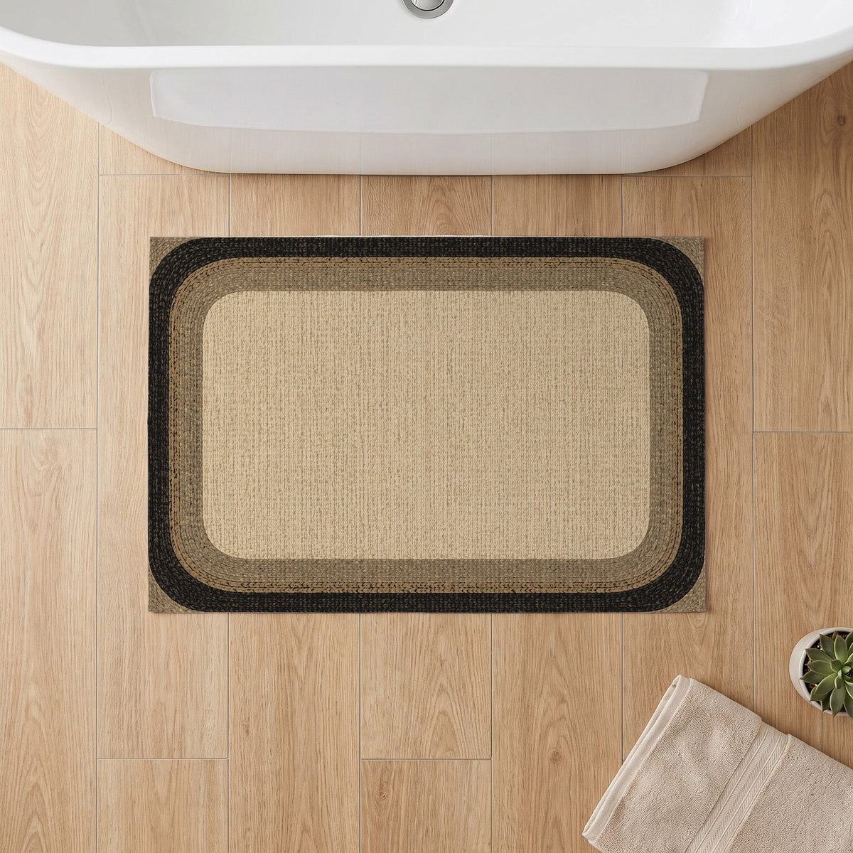 Kartela Jute Frame washable jute-look bath mat in Natural Black, on a wooden floor in front of a bathtub