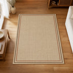 Kartela Double Frame washable jute-look double border area rug in Beige, on a wooden floor in a bright living room