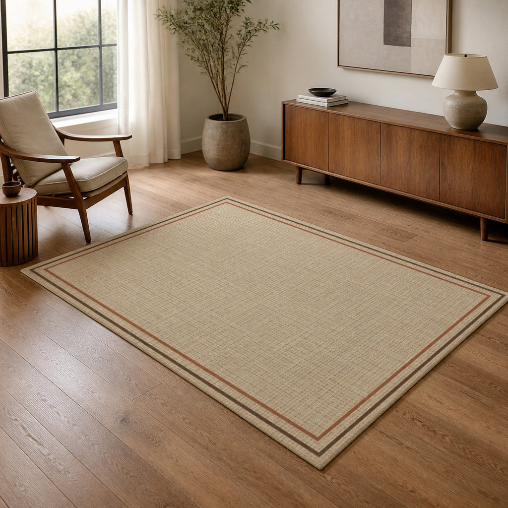 Kartela Double Frame washable jute-look double border area rug in Beige, in a living room with an armchair and sideboard