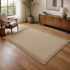 Kartela Double Frame washable jute-look double border area rug in Beige, in a living room with an armchair and sideboard