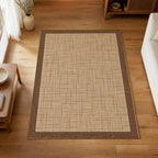 Kartela Jute Frame washable jute-look bordered area rug in Beige, on a wooden floor in a bright living room