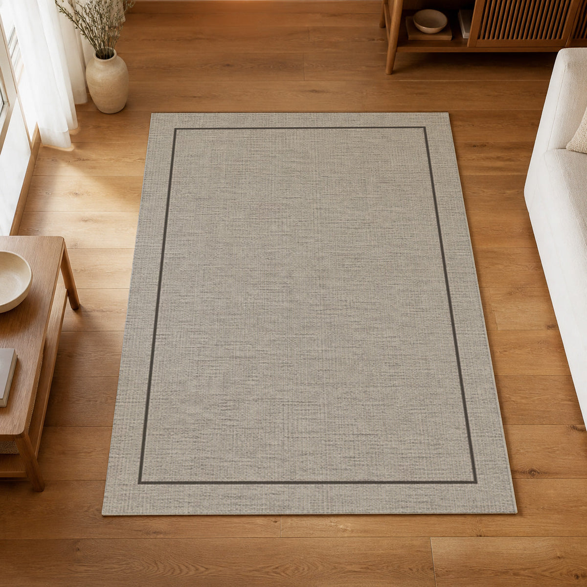 Kartela Sisal Line washable sisal-look minimal area rug in Light Gray, on a wooden floor in a bright living room