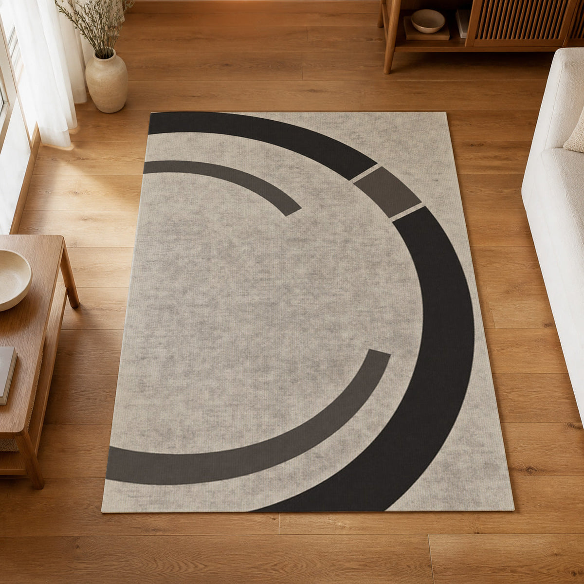 Kartela Orbit washable modern circle area rug in Charcoal, on a wooden floor in a bright living room