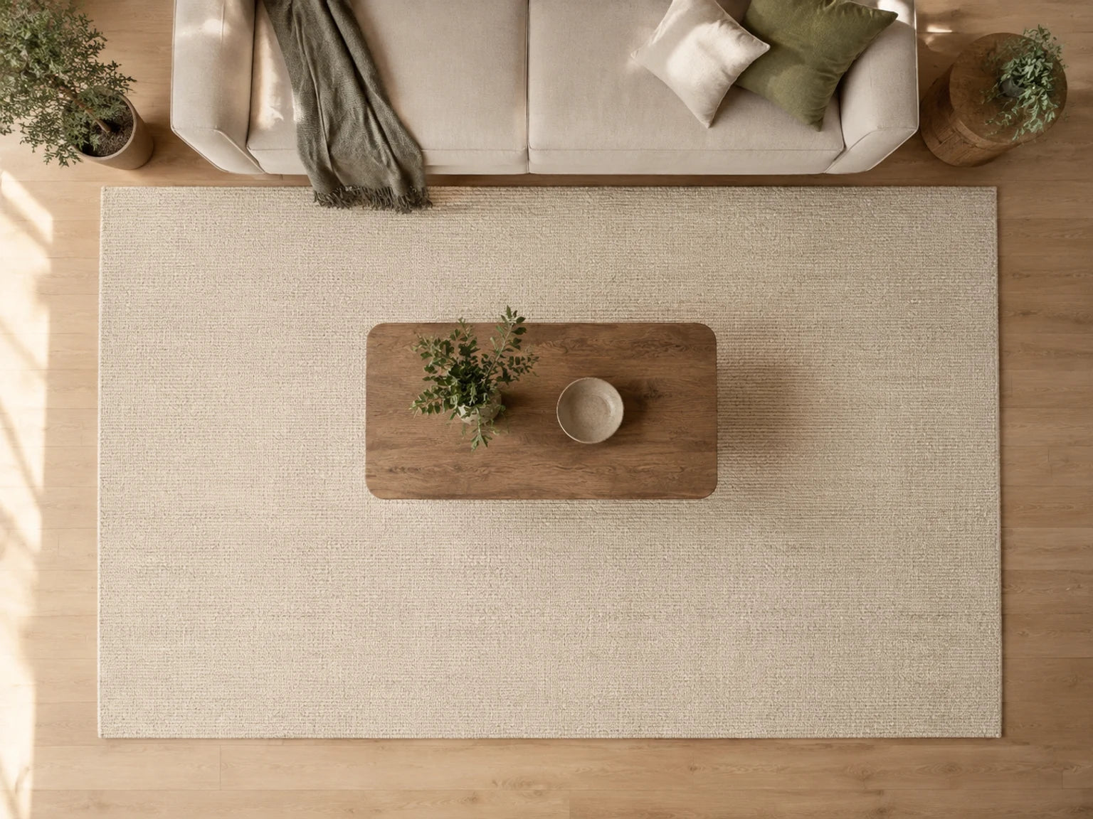 Neutral living room showing how different area rug sizes fit beneath a sofa and coffee table